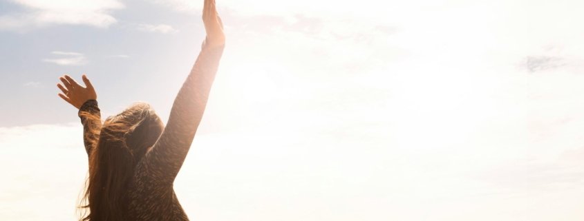 Woman enjoying life with hands raised in the air